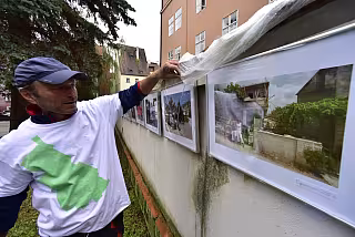 Pracovník galerie přikrývá vystavené fotogafie