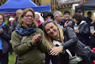 Lidé stojící u pódia užívající si koncert